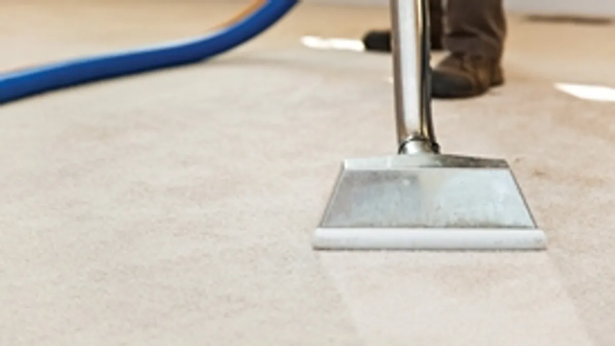 Carpet cleaning wand head gliding over a light carpet during hot-water extraction, Dallas, TX.